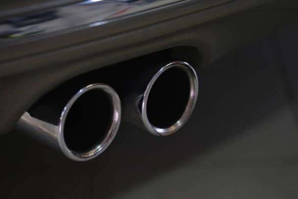 Tubo de escape cromado duplo de carro esportivo poderoso com corpo preto e peças de plástico cinza - Foto, Imagem