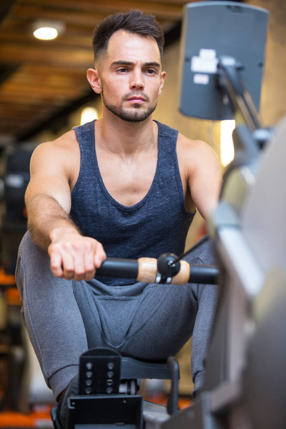young handsome man doing exercises in gym - Fotoğraf, Görsel