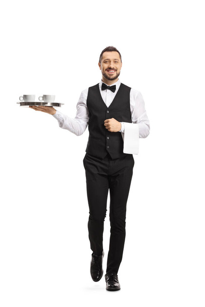 Full length portrait of a waiter serving coffee on a tray isolated on white background - Foto, imagen