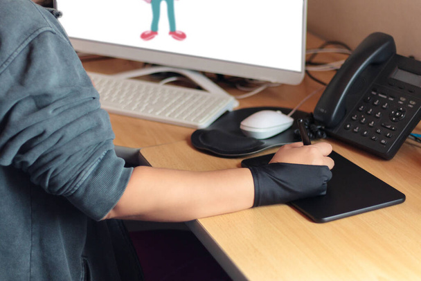 Χέρι ενός συντάκτη με ένα γραφικό δισκίο με τον υπολογιστή - Φωτογραφία, εικόνα