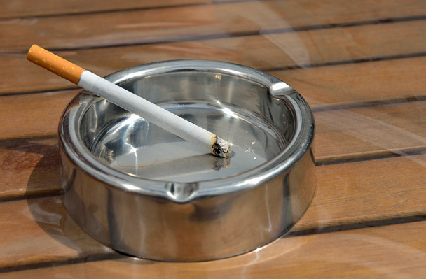 木製テーブルの上にタバコを金属製の灰皿 - 写真・画像