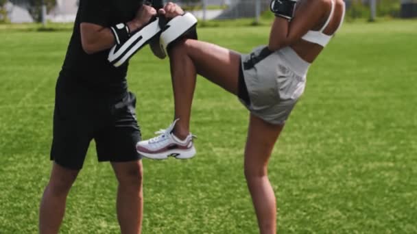 Jeune femme ayant un entraînement de boxe avec son entraîneur masculin - coups de pied dans les mitaines avec son genou - Séquence, vidéo