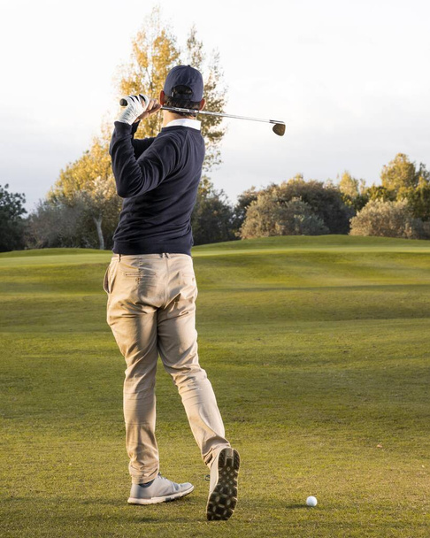 uomo vista posteriore giocando campo da golf erboso. Foto di alta qualità - Foto, immagini