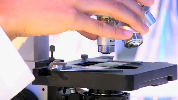 Використовуючи мікроскоп в лікарні науково-дослідна лабораторія - Кадри, відео