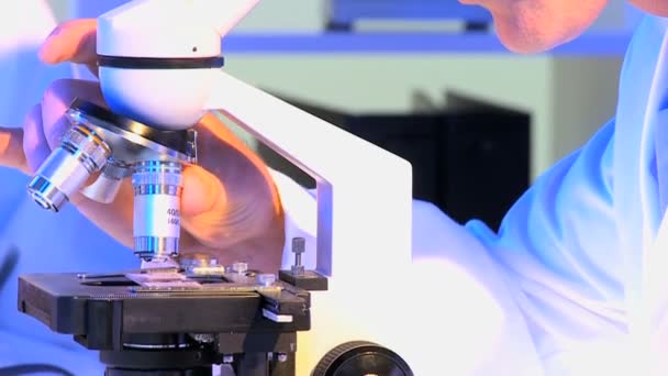 顕微鏡で働いている男性の研究助手 - 映像、動画