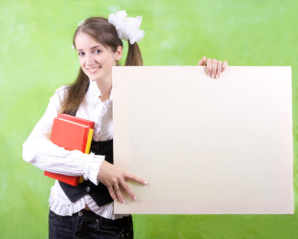 Schoolgirl holds blank canvas - Fotó, kép