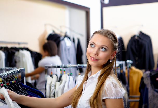 Young woman in a shop buying clothes - Foto, imagen