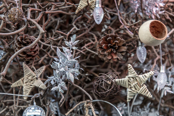 Close-up of Decorating Christmas tree background. Twigs christmas tree, brown natural pine cones, Disco ball, Star and edison light bulb, Selective focus. - Fotografie, Obrázek