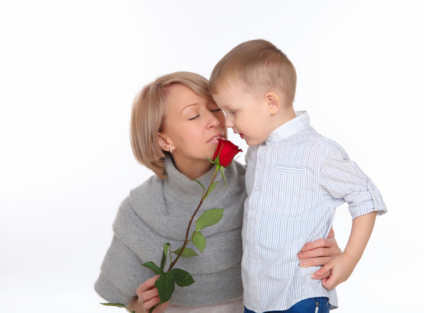 Mother and son holding a red rose - Foto, afbeelding
