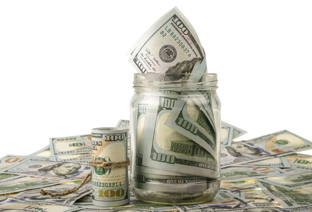 Money in the jar placing on US dollar banknotes - Foto, imagen