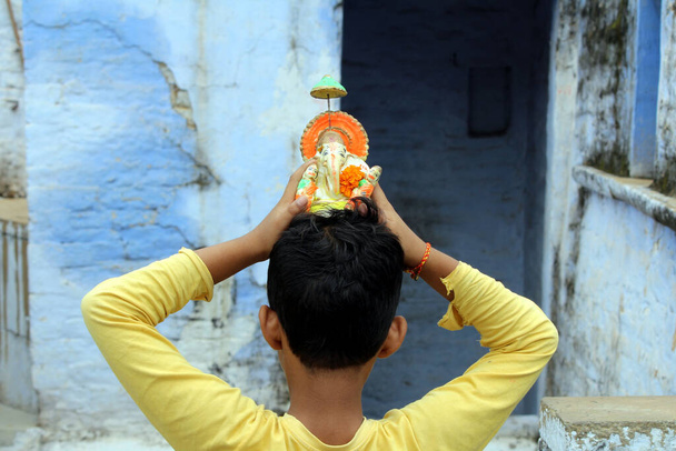 een jongen aanbidding heer shri ganesha - Foto, afbeelding