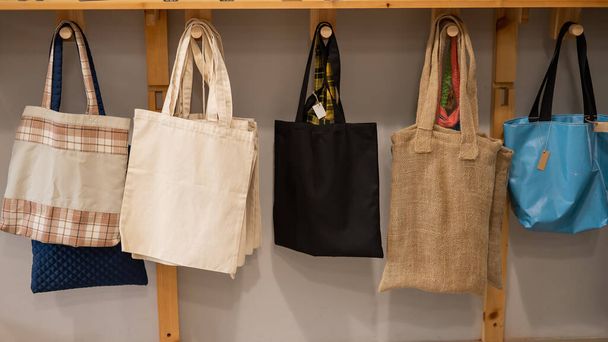 Choosing cotton bags in an eco-friendly store. - 写真・画像