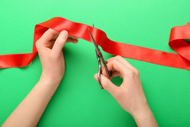 Mujer cortando cinta roja sobre fondo verde - Foto, Imagen