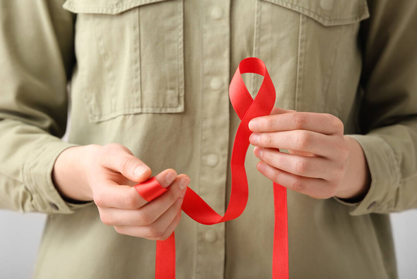 Woman holding red ribbon. AIDS awareness concept, closeup - Photo, Image