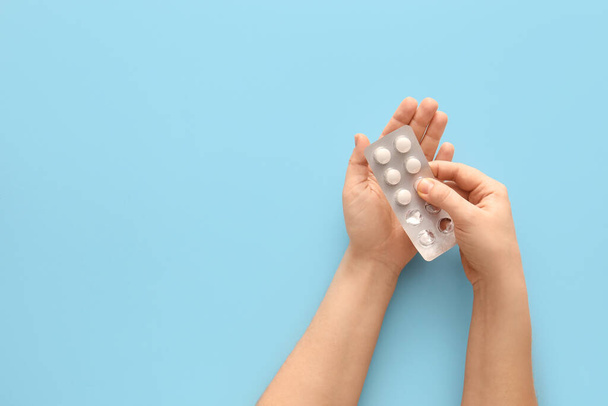 Female hands with pills on blue background - Foto, Bild
