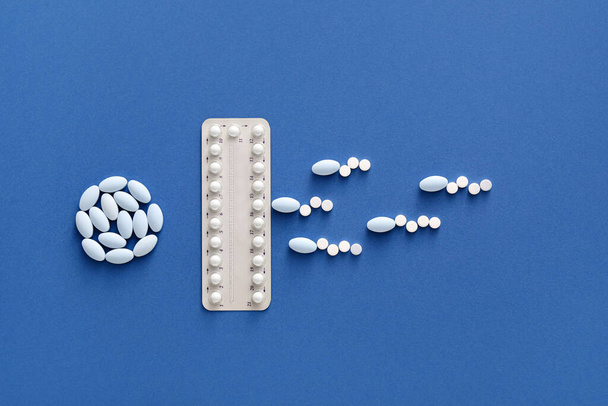 Kreatív összetétel fogamzásgátló tabletták kék háttérrel. Biztonságos szex fogalma - Fotó, kép