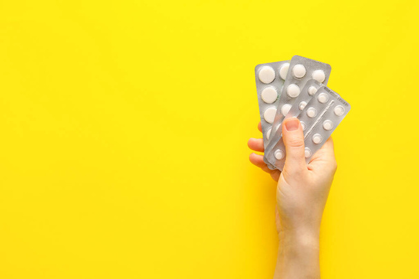 Female hand with pills on color background, closeup - Foto, Imagen