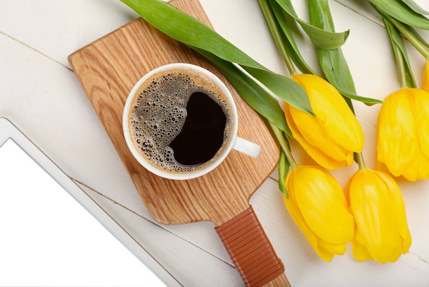 Tasse Kaffee und Tulpen auf hellem Holzhintergrund - Foto, Bild