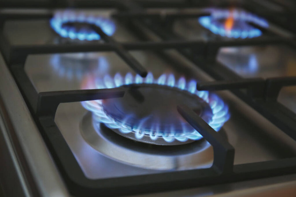 Palnik gazowy z niebieskim płomieniem na kuchence domowej, zbliżenie - Zdjęcie, obraz
