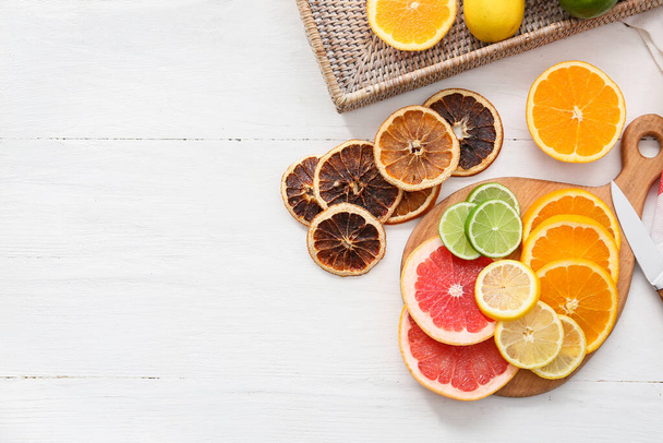 Slices of fresh and dried citrus fruits on light wooden background - Photo, Image
