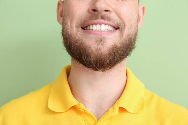 Junger Mann mit gesundem Zahnfleisch auf farbigem Hintergrund, Nahaufnahme - Foto, Bild