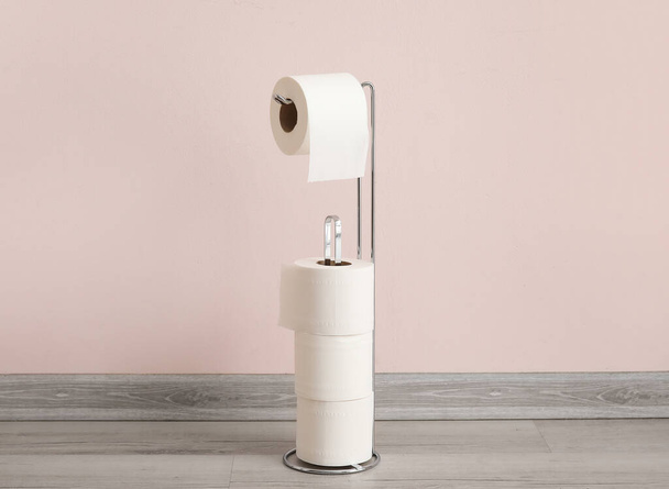 Support avec rouleaux de papier toilette près du mur léger - Photo, image