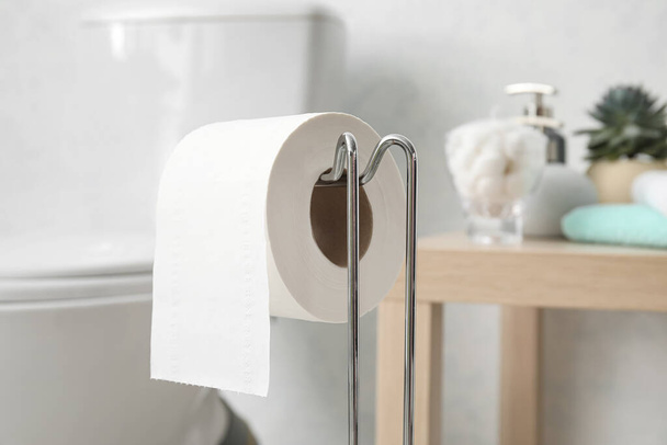 Holder with toilet paper roll in light restroom, closeup - Photo, Image