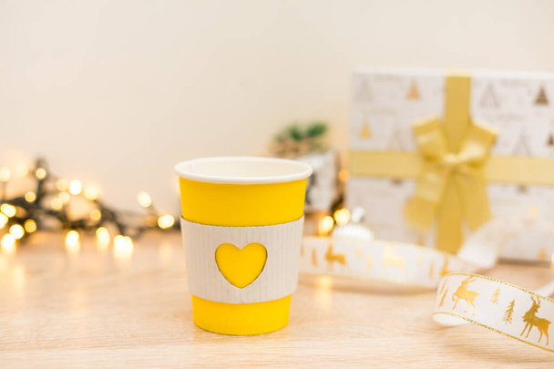 Зніміть чашки кави на фоні золотих вогнів з різдвяними подарунками. Високоякісна фотографія
 - Фото, зображення