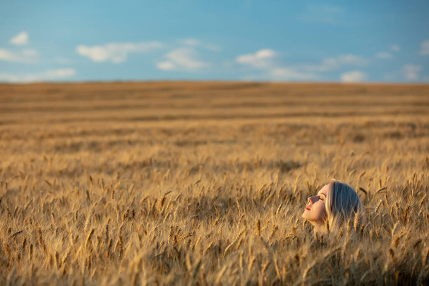 Блондинка без одежды на пшеничном поле на закате  - Фото, изображение