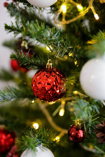 close up of red bauble on decorated christmas tree - Foto, imagen