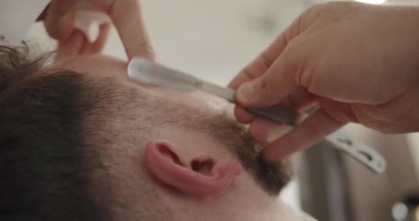 Barbier professionnel rasage barbe client avec rasoir droit  - Séquence, vidéo