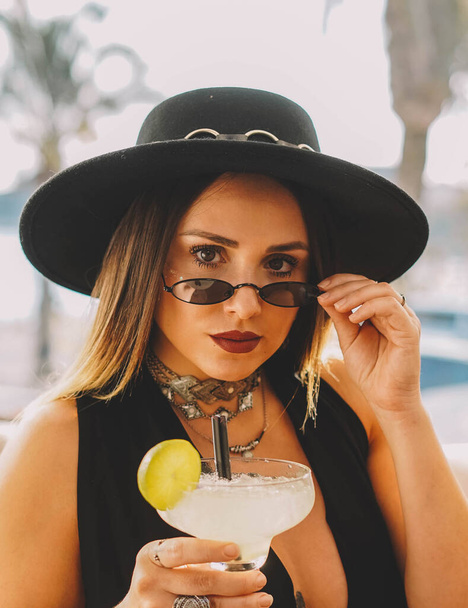 Woman with hat drinking a frozen margarita - Фото, зображення