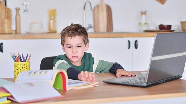 jongen studeert op een online school, toont het antwoord op de vraag via video communicatie - Foto, afbeelding