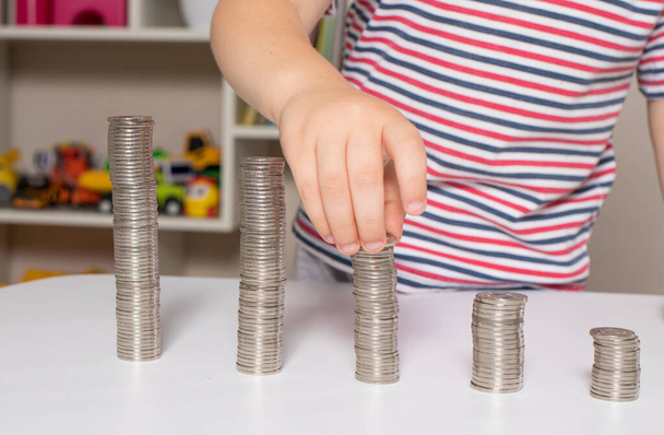 子供とコイン-子供のための金融リテラシー、お金を使うことを学ぶ - 写真・画像