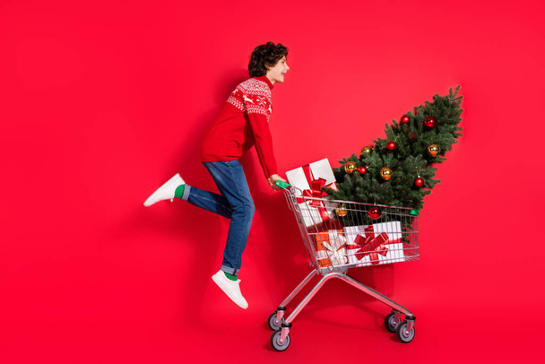 Profile photo of funny boy jump fly enjoy shopping wear deer ornament sweater isolated red color background - Φωτογραφία, εικόνα