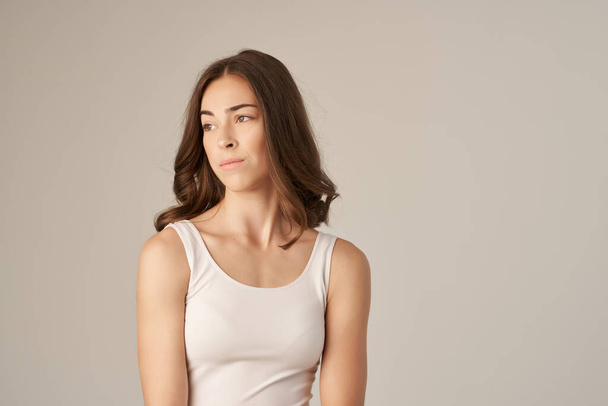όμορφη γυναίκα σε ένα λευκό t-shirt περιποίηση μαλλιών Studio Lifestyle - Φωτογραφία, εικόνα