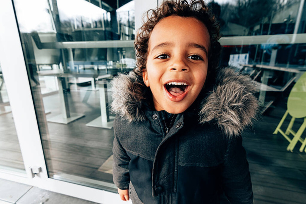 close up portrait of a happy smiling african american little kid in winter - Photo, Image