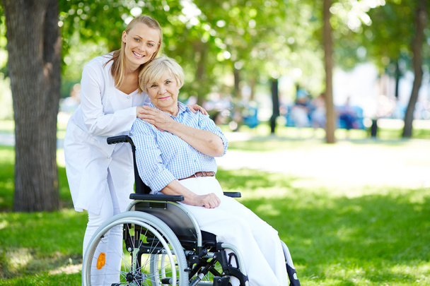 Enfermera y paciente sénior en silla de ruedas
 - Foto, Imagen