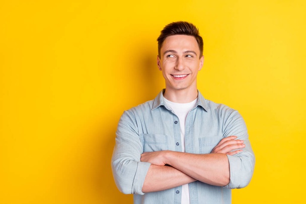 Portrait of attractive cheerful content guy folded arms copy blank space ad clue guess isolated over bright yellow color background - Zdjęcie, obraz