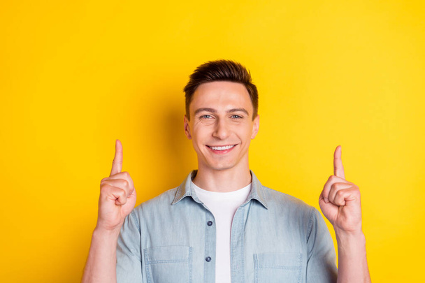 Photo of young cheerful smiling guy man point finger up advertisement big sale black friday isolated on yellow color background - Photo, image