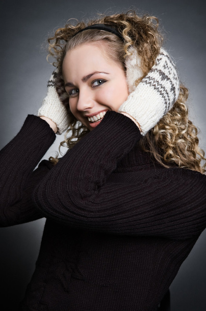 schöne Smiley-Frau in Strickhandschuhen und Fell-Kopfhörern - Foto, Bild