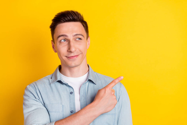 Photo of young handsome good looking dreamy guy look copyspace advertise product isolated on yellow color background - Photo, image