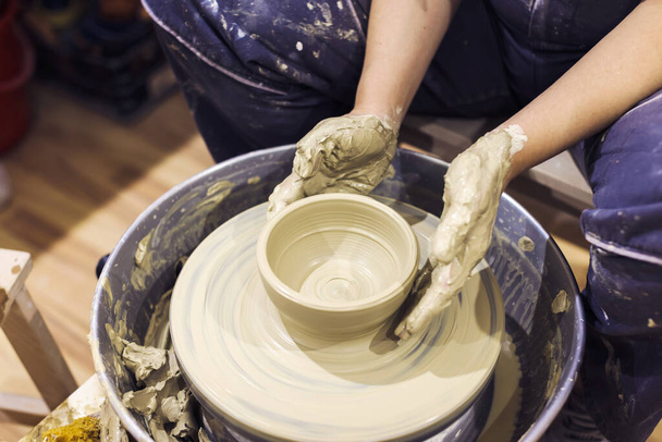 Çanak çömlek sanatçısı çömlek çarkında, sanat atölyesinde kilden vazo yapıyor.. - Fotoğraf, Görsel