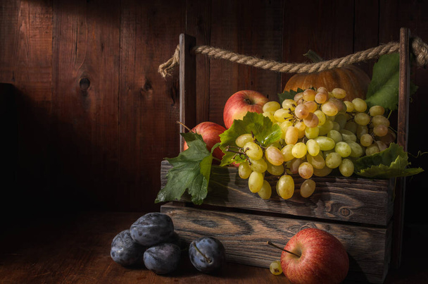 viinirypäleet ja muut hedelmät tumma puinen tausta maalaismainen tyyli - Valokuva, kuva