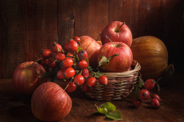 素朴なスタイルで暗い木の背景にリンゴや他の果物 - 写真・画像