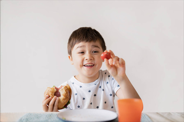 Kid eating whole grain bagels for his breakfast,School boy eating donut healthy Child eating bread and juice drink for his breakfast.Healthy Children concept - Foto, immagini