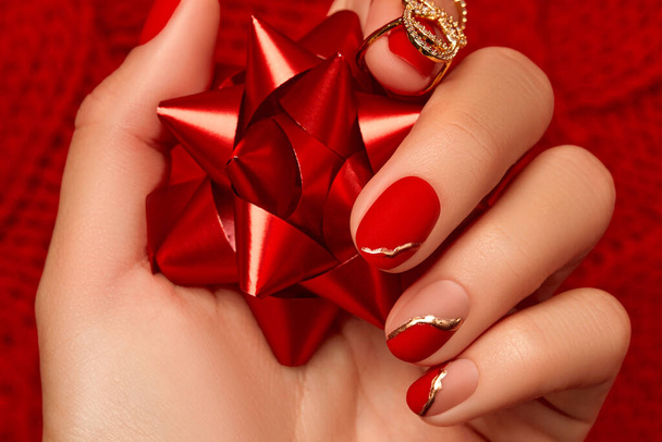 Womans hand with fashionable red manicure close up. Manicure, pedicure beauty salon concept. - Photo, Image