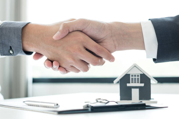 Üzletemberek és brókerek ingatlanügynökei kezet ráznak, miután befejezték a lakásbiztosításról és a szerződések aláírásáról szóló tárgyalásokat. Lakásbiztosítás fogalma. - Fotó, kép