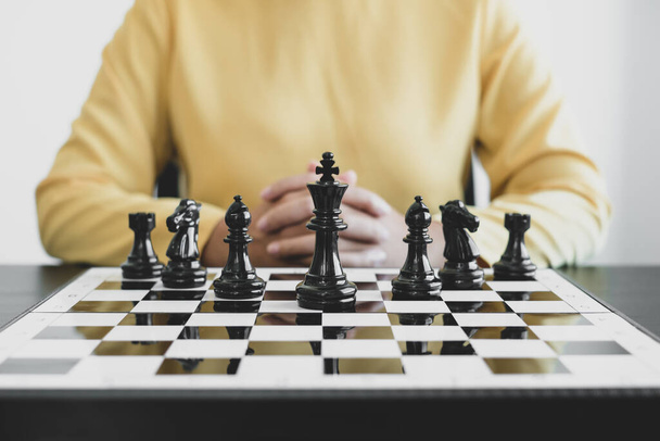 チェスボードはリーダーシップを示し、ビジネスウーマンの手は動き、競争のチェスはリーダーシップ、フォロワー、ビジネス成功戦略を示しています。. - 写真・画像