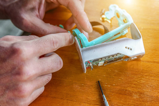 Man hands fixing modern vaporizer e-cig gadget to vape e-liquid. Maintenance of electronic equipment mech mod vaping device. Vaper device repair service - Φωτογραφία, εικόνα